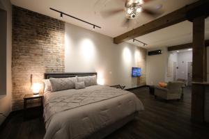 a bedroom with a large bed and a brick wall at Gibson's Warehouse in Staunton