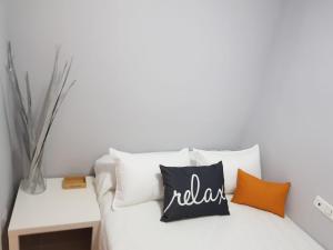 białe łóżko z pomarańczowymi i białymi poduszkami w obiekcie Apartamento Delicia 1 w mieście Benalmádena +19 zdjęć