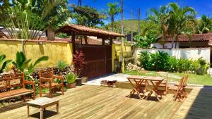 a backyard with a wooden deck with a table and chairs at Sunset Maresias -Casas e Chalés C2 in Maresias
