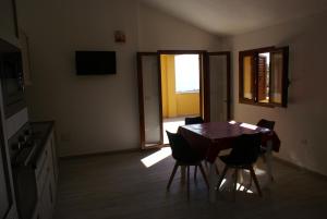uma sala de jantar com uma mesa de madeira e cadeiras em casa mariolu 2 piano mansarda em Cala Gonone