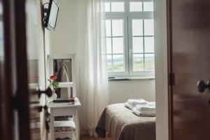 um pequeno quarto com uma cama e uma janela em YEY Atouguia da Baleia em Peniche