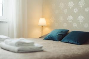 um quarto com uma cama com almofadas azuis e um candeeiro em YEY Atouguia da Baleia em Peniche
