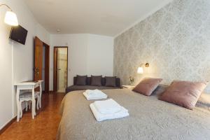 1 dormitorio con 1 cama grande y toallas. en YEY Atouguia da Baleia, en Peniche