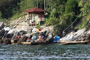 a group of chairs and umbrellas on a dock on the water at Hotel Stanger in Lovran
