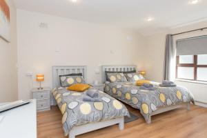 a bedroom with two beds and two windows at The Arch Accommodation in Carrick-on-Suir