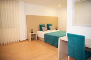 Un dormitorio con una cama con sábanas verdes y una ventana en Quinta do Viso Alojamento Local, en Miranda do Corvo