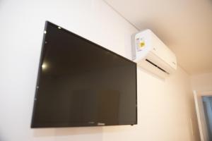a flat screen tv hanging on a wall at Quinta do Viso Alojamento Local in Miranda do Corvo