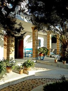 een veranda van een huis met potplanten bij Hotel Villa Soleil in Sidi Kaouki