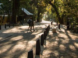 a person walking down a sidewalk in a park at Lunas Apartment in Palenque