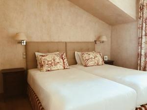 a bedroom with two beds with white sheets and pillows at Quinta De Catralvos in Azeitao