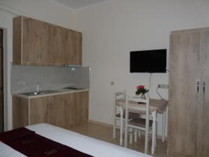 Habitación con cocina con fregadero y mesa. en Apartment Dejvi, en Sarandë