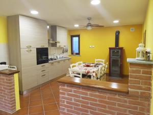 cocina con paredes amarillas, mesa y sillas en AleKS friendly house en Canale