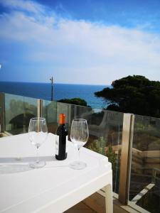 a white table with two glasses and a bottle of wine at Casa João Bravo in Albufeira