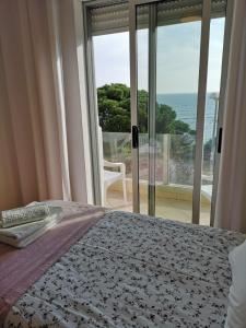 a bedroom with a bed and a view of the ocean at Casa João Bravo in Albufeira