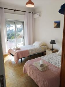 a bedroom with two beds and a window at Casa João Bravo in Albufeira