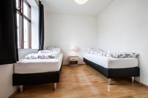2 Betten in einem Zimmer mit Holzböden in der Unterkunft Stay Iceland apartments - B 22a in Reykjavík
