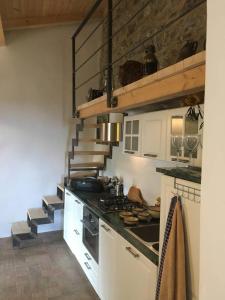 a kitchen with a stove top oven next to a staircase at Lovely renovated apartment near Dolcedo in Dolcedo