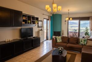 sala de estar con sofá y TV en Nikol apartment, en Argostoli