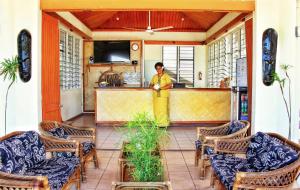 a man standing at the counter of a restaurant at Hotel Oasis in Nadi