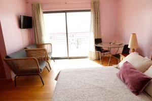 1 dormitorio con 1 cama, 1 silla y 1 mesa en BellaVita City Faro, en Faro