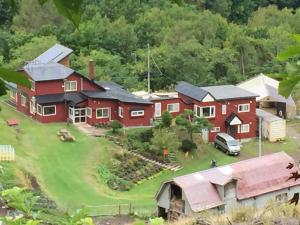 een luchtzicht op een rood huis met een groene tuin bij Farm Inn Anima no Sato in Abashiri