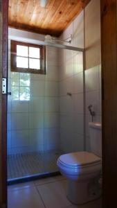 a bathroom with a toilet and a glass shower at Pousada Camping Porto Grande in Meaípe +240 photos