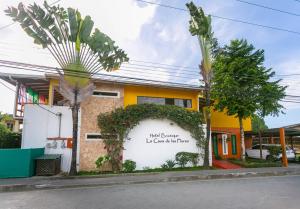 a house with a sign on the side of it at Hotel Boutique La Casa de las Flores in Cahuita