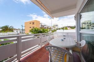 patio con mesa y sillas en el balcón en Las Adelfas By CanariasGetaway, en San Agustín