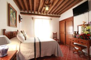 Schlafzimmer mit einem Bett, einem Fenster und einem Tisch in der Unterkunft Hotel Mesón del Rosario in Guanajuato