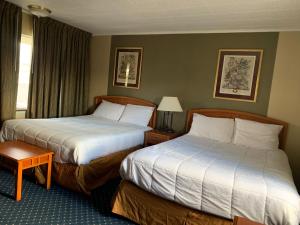 a hotel room with two beds and a window at Scottish Inns Fayetteville in Fayetteville
