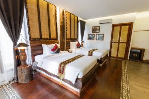 Giường trong phòng chung tại Khmer Paradise Villa