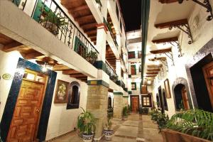 a hallway of a building with potted plants at Hotel Mesón del Rosario in Guanajuato