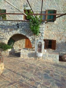a stone building with a door and a balcony at Peace in the wildest landscape of Mani in Láyia