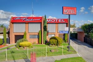 una señal de motel frente a un edificio en Always Welcome Motel, en Morwell