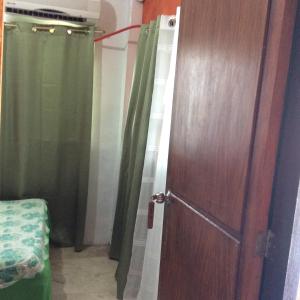 uma porta para um quarto com cortinas verdes em Troy Lodge em Basco