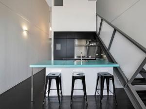 una cucina con bancone blu e sgabelli di The Miro Apartments a Brisbane