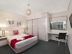 a hotel room with a bed and a desk at The Miro Apartments in Brisbane