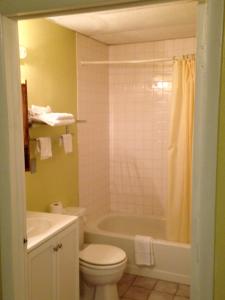 a bathroom with a tub and a toilet and a sink at Red Carpet Inn Niagara Falls in Niagara Falls