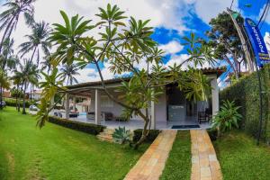 a house with a garden and a roller coaster at Recanto do Aconchego in Porto De Galinhas