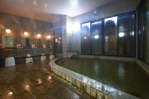 a bathroom with a large pool of water with mirrors at Stardust Village Hossyo in Kokonoe