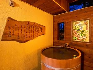 a wooden barrel in a room with a window at HAKONE GORA ONSEN Hotel Kasansui in Hakone