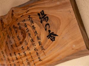 a wooden cutting board with asian writing on it at HAKONE GORA ONSEN Hotel Kasansui in Hakone