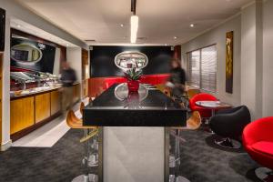 un bar in un ristorante con sedie rosse di CityLife Wellington a Wellington