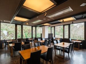 a dining room with tables and chairs and windows at HAKONE GORA ONSEN Hotel Kasansui in Hakone