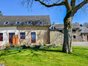 an old stone house with a tree in the yard at Charming Holiday Home in Bonnemain overlooking a Pond in Bonnemain
