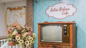 un televisor con un ramo de flores encima en Hotel Ciudad Latin Palace, en Guayaquil