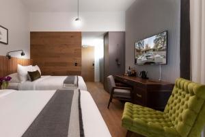 um quarto de hotel com duas camas, uma secretária e uma cadeira em Park James em Menlo Park
