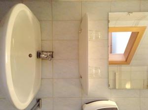 ein Badezimmer mit WC, Urinal und Spiegel in der Unterkunft Frühstückspension zur Post Reisinger KG St Oswald in Sankt Oswald bei Freistadt