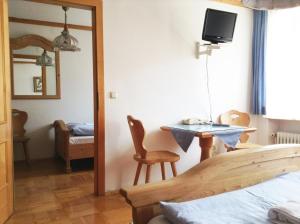 ein Schlafzimmer mit einem Spiegel, einem Tisch und einem Bett in der Unterkunft Frühstückspension zur Post Reisinger KG St Oswald in Sankt Oswald bei Freistadt