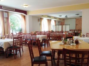 ein Esszimmer mit Tischen und Stühlen in einem Raum in der Unterkunft Frühstückspension zur Post Reisinger KG St Oswald in Sankt Oswald bei Freistadt